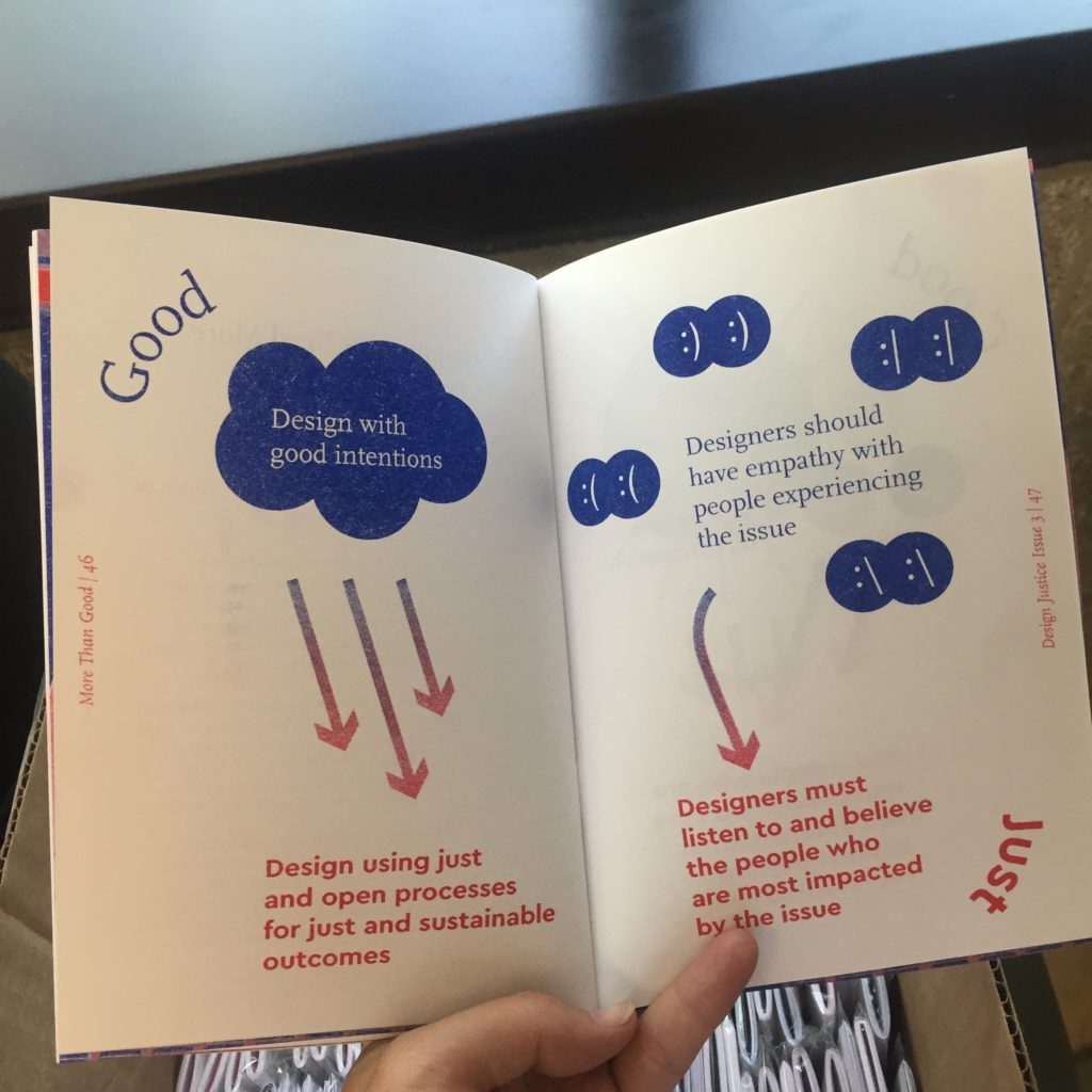 A persons hand holds a copy of the Design Justice zine open. The spread includes illustrations representing the differences between "Design for Good" and "Design Justice." 