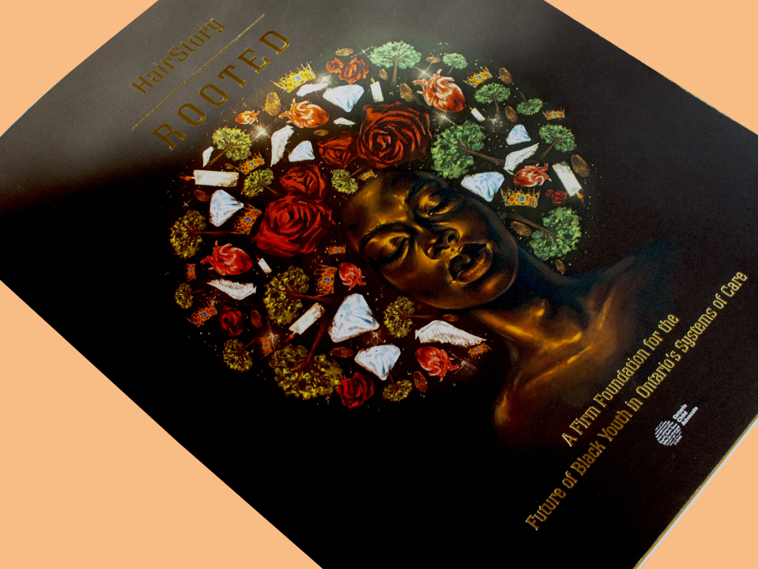 Photo of a report entitled HairStory—Rooted. On the front the cover is a Black woman with her eyes closed. Her face is framed by an Afro made up of images such as candles, trees, roses, and wings. The title is stamped onto the book in gold.