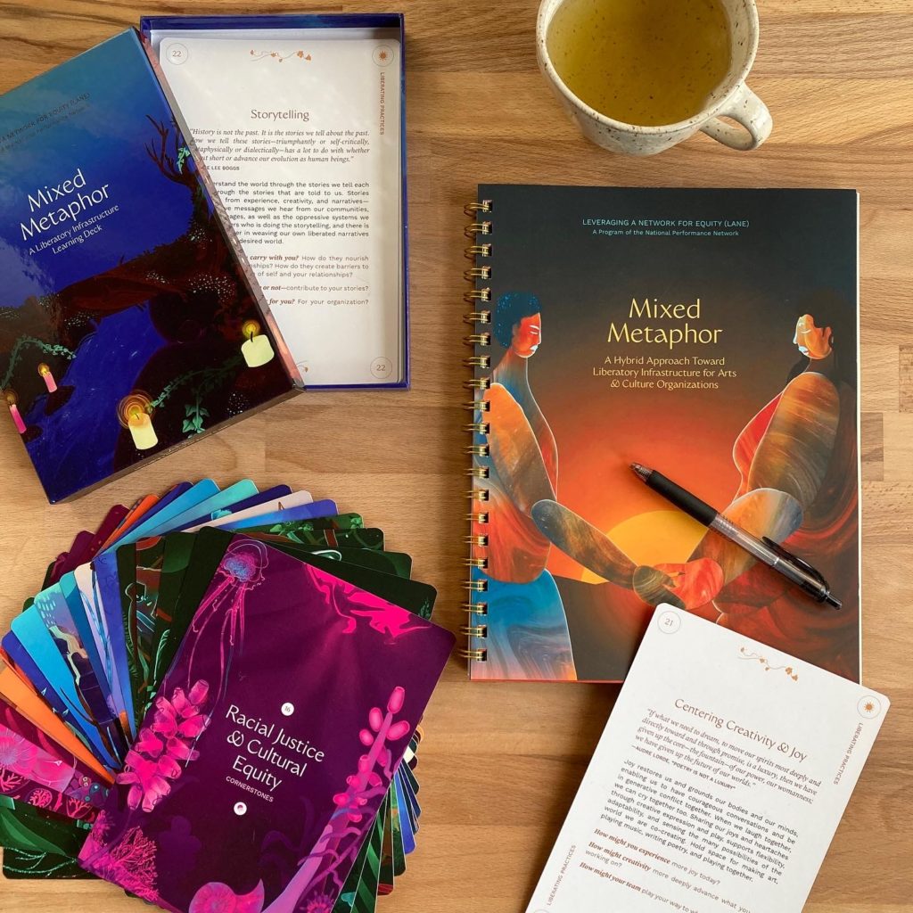 An image of Mixed Metaphor booklet and card deck splayed out on a desk with a mug of tea